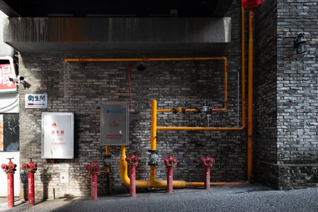 Urban Wall with Hydrants and Piping in Alley